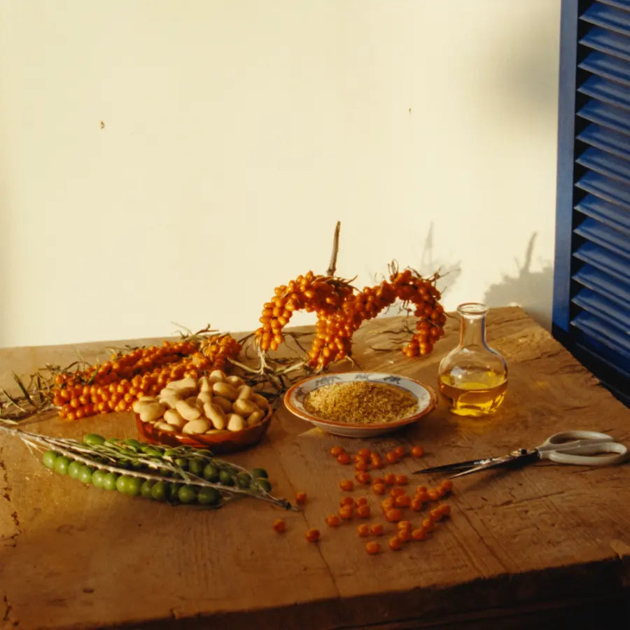 Les ingrédients de l'huile posés sur une table en bois